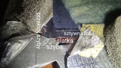 Rozwarstwiony przekrój szyby z widoczną siatką, folią i klejem