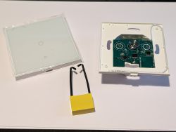 Disassembling the Ener-J Touch Switch Disassembled white touch switch with visible PCB and capacitor.