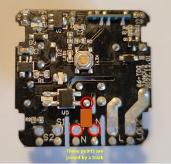 Close-up of a circuit board with three points highlighted in red circles, connected by a path.