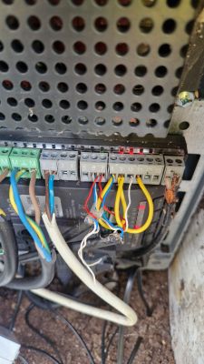 Zbliżenie na panel sterowania z podłączonymi przewodami elektrycznymi.