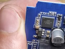 Close-up of T34 chip on blue PCB with 16V 220µF capacitor and SMD components