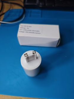 Tuya G9 Smart LED Bulb with White Box A Tuya G9 smart LED bulb lies on a blue surface next to a white box.