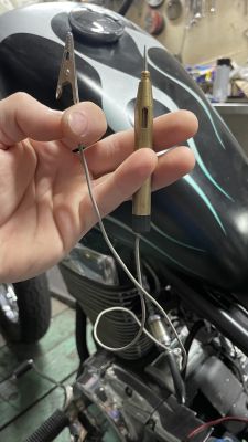 Ręka trzymająca próbnik elektryczny w motocyklu