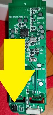 Close-up of a circuit board with electronic components, highlighted by a large yellow arrow.