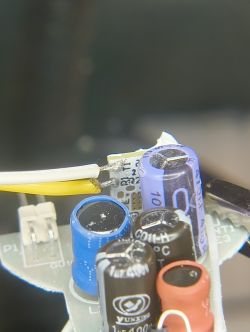Close-up of electrolytic capacitors and wires on a PCB