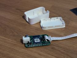 Open Casing with BK7231T Board on Table Circuit board with open casing on a wooden surface.