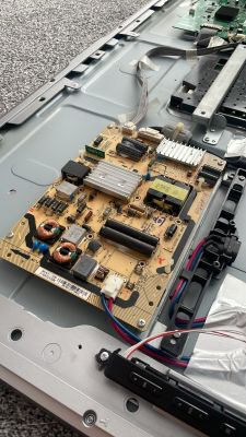 Zdjęcie wnętrza telewizora z widoczną płytką elektroniczną.