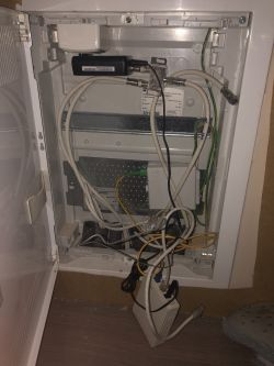 Skrzynka elektryczna z podłączonymi kablami i urządzeniami w szafie.