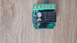 Close-up of a green printed circuit board with electronic components on a wooden surface.