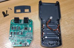 Rozkręcony tester kabli z widoczną płytką PCB i wnętrzem obudowy z miejscem na baterie