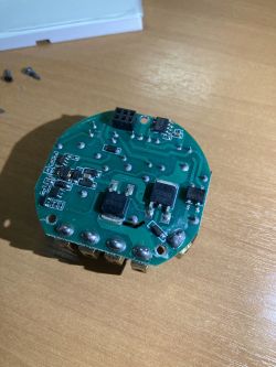 Close-up of a circuit board with electronic components on a wooden table.