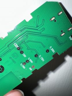 Close-up of a green circuit board with visible traces and pin labels.