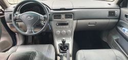Interior of a Subaru car showing the steering wheel, dashboard, and center console.