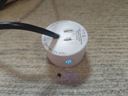 Smart Plug RMC003 with LED Smart plug RMC003 with blue LED on a carpet.