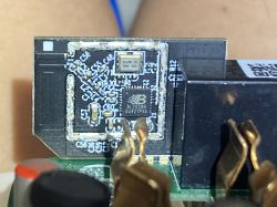 Close-up of a small electronic module on a PCB with an IC and SMD components