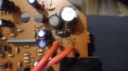 Zbliżenie na płytkę drukowaną z elementami elektronicznymi i zaznaczeniem strzałką.