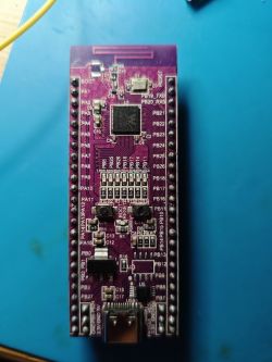 Printed circuit board with purple laminate on a blue background.