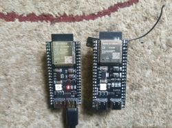 Two ESP32 modules on a carpet, one with Espressif logo.