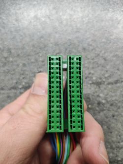 Zbliżenie na zieloną kostkę elektryczną z wieloma małymi otworami.