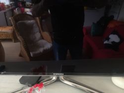 Odbicie wnętrza pokoju w ekranie telewizora Samsung.
