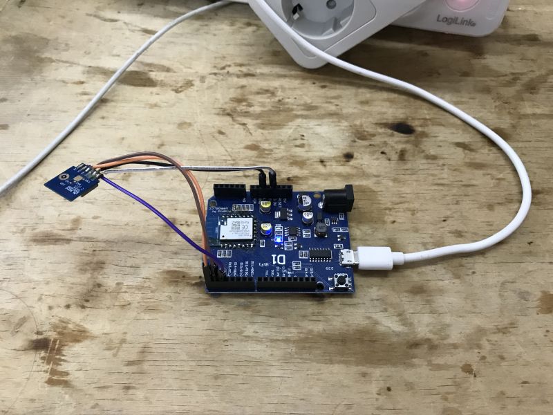 Development board with connected module via jumper wires on a wooden table