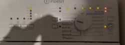 Panel pralki Indesit z podświetlonymi kontrolkami i pokrętłem programów