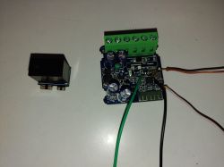 Circuit board with green screw terminal and connected wires, plus a separate black relay module