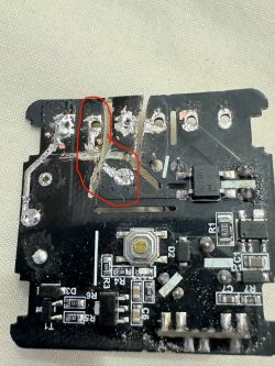 A printed circuit board with damage and an outlined area in red lines.