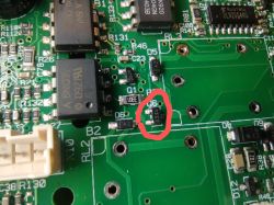 Zbliżenie na płytę PCB z zaznaczonym czerwonym okręgiem elementem SMD oznaczonym jako Q50, prawdopodobnie tranzystor.