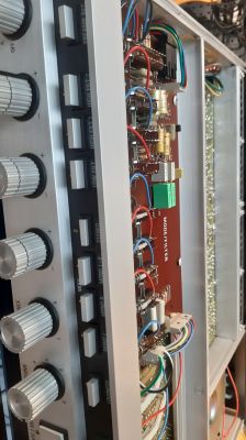 Zbliżenie na płytkę elektroniczną wewnątrz urządzenia audio z widocznymi potencjometrami i przewodami.