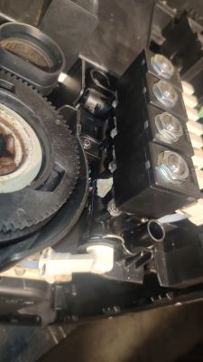 Wnętrze ekspresu do kawy z widocznym mechanizmem zębatym i zespołem elektrozaworów, okolice możliwego wycieku wody.