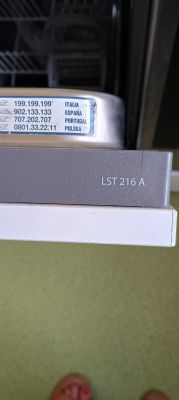 Tabliczka z numerami telefonów serwisowych i oznaczeniem modelu LST 216 A na zmywarce.