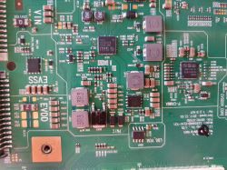 Zbliżenie na płytkę drukowaną z widocznymi różnymi układami scalonymi i komponentami elektronicznymi.