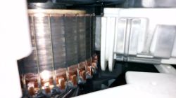 Zbliżenie na komutator silnika pralki z widocznymi szczotkami węglowymi
