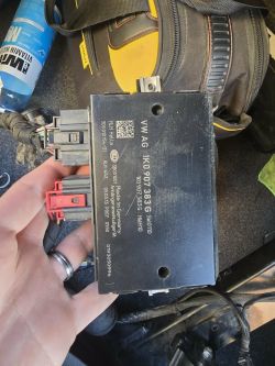 Steuergerät VW AG 1K0 907 383 G Hella mit schwarzen und rotem Stecker, in der Hand gehalten