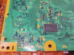 Widok na zieloną płytę PCB z różnorodnymi komponentami elektronicznymi.