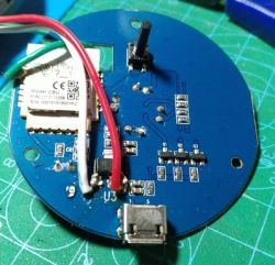 A circuit board with electronic components, including a Wi-Fi module and wires.