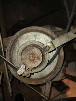 Widok z góry na mechanizm traktorka kosiarki z zardzewiałą nakrętką.