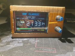 Electronic display in a cardboard case showing RMF Classic station and weather data