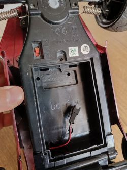 Wnętrze zabawkowego auta RC z pustą komorą na akumulator 7.2V i dwupinowym złączem.