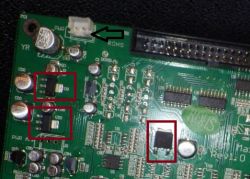 Nahaufnahme einer Leiterplatte mit einem markierten Anschluss und mehreren elektronischen Bauteilen in roten Rechtecken.