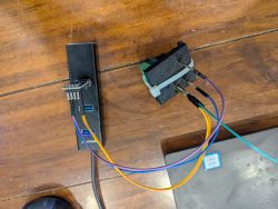 Wires connected to a USB hub and a small electronics module on a wooden tabletop