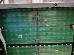 Zbliżenie na płytę PCB z zainstalowanymi układami scalonymi i przewodami.