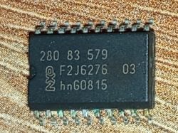 Układ scalony NXP z oznaczeniem 280 83 579 F2J6276 03 na tle drewnianym