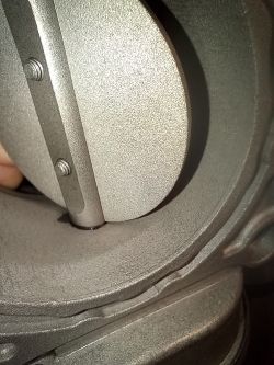 Zbliżenie na metalowy element z widocznymi śrubami.