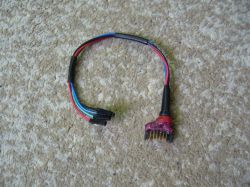 Adapter kablowy DIY z czterema przewodami (czerwony, niebieski, zielony, czarny) i wtykiem goldpin na tle wykładziny.