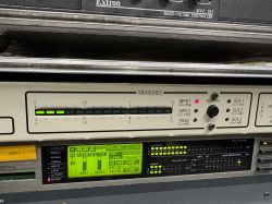 Panel urządzenia audio w racku z diodami i wyświetlaczem, m.in. MPX1 i 19 kHz