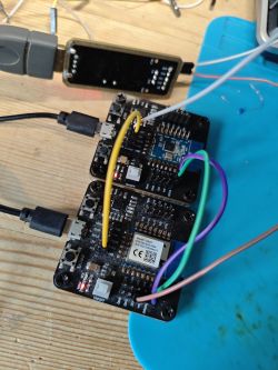 Two connected electronic modules with colored wires on a wooden workbench.