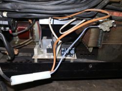 Zbliżenie na wnętrze urządzenia z przewodami i komponentami elektrycznymi.