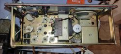 Widok wnętrza obudowy urządzenia elektronicznego z gniazdami lamp elektronowych i transformatorami